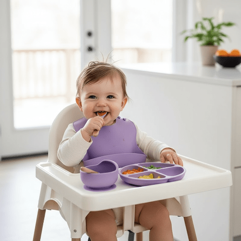 Bébé avec Bavoir Utilisant le Set Vaisselle Violet Translucide